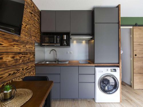 une cuisine avec un lave-linge et un lave-linge dans l'établissement T2 rénové avec parking proche centre et télécabine - FR-1-401-267, à Cauterets