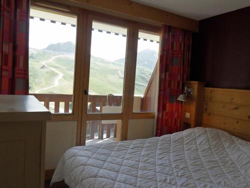 une chambre avec un lit et une grande fenêtre dans l'établissement Appartement 3 pièces · Pied des pistes · Balcon · 7 pers - FR-1-181-2721, à La Plagne Tarentaise