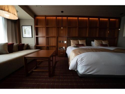 a hotel room with two beds and a couch at Hotel Grand View Takasaki - Vacation STAY 55450v in Takasaki
