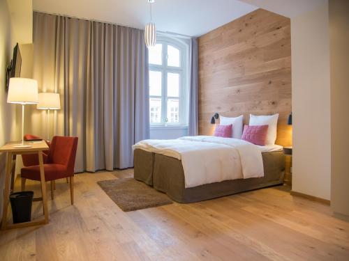Schlafzimmer mit einem Bett, einem Schreibtisch und einem Stuhl in der Unterkunft Hotel Alte Post Flensburg in Flensburg