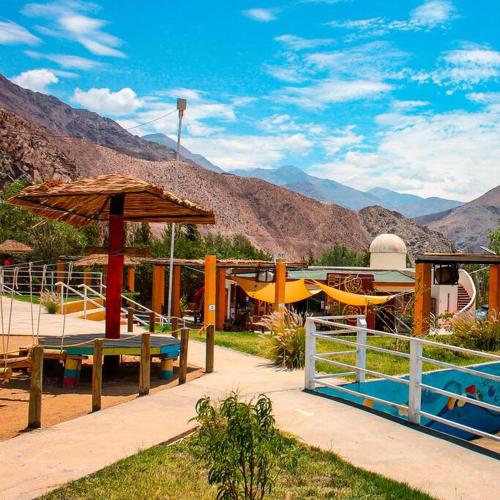 a resort with a playground with a pool and an umbrella at Cabaña Altos de Chanchoqui in Paihuano