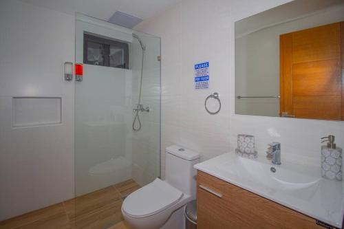 a bathroom with a shower and a toilet and a sink at Brand New Luxury Home in Santo Domingo