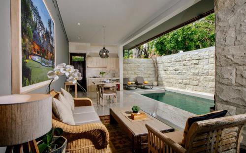 a living room with a pool and a large window at Alindra Villas & Spa in Nusa Dua