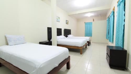 1 dormitorio con 2 camas y TV. en Hotel Vias Maya Bacalar en Bacalar