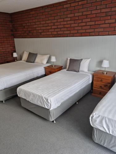 a room with two beds and two night stands at Mid City Plantation Motel in Mildura
