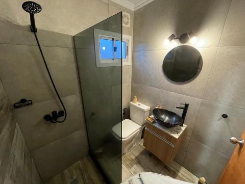a bathroom with a shower and a toilet and a sink at Lo de Joaco y Marti in Punta Del Diablo