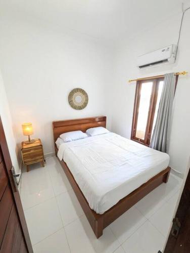 een slaapkamer met een bed en een raam bij Mini tropical home with office in Krambitan
