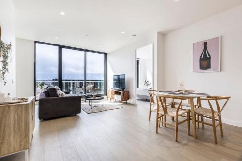 a living room with a table and a couch at Moonee Valley Park with parking in Melbourne