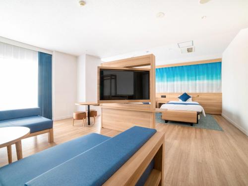 1 dormitorio con 1 cama y TV en una habitación en Resort Hotel Kume Island, en Kumejima
