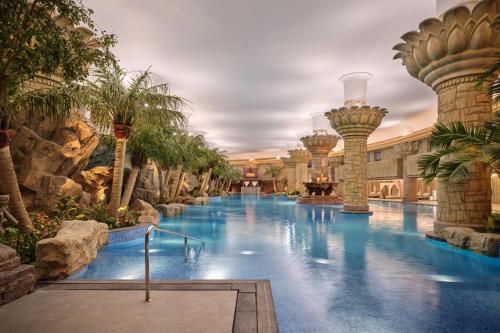 - une piscine dans un hôtel avec des palmiers dans l'établissement Grand Hyatt Beijing, à Pékin
