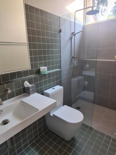 a bathroom with a toilet and a sink and a shower at Allure Stradbroke Resort in Point Lookout