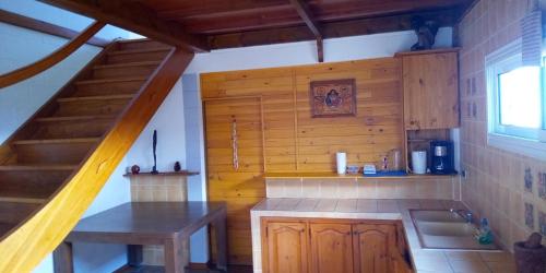 a kitchen with a staircase in a wooden house at Le Tranquillou in La Plaine des Cafres