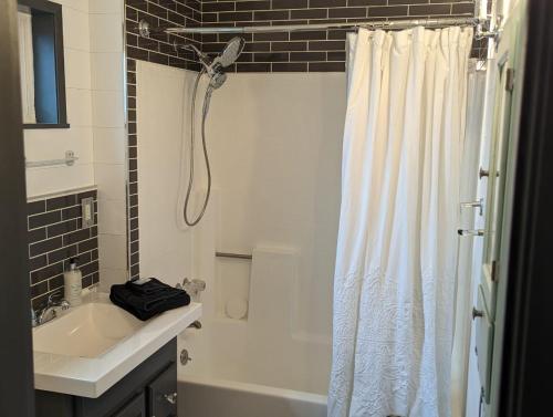 a bathroom with a white shower curtain and a sink at Red Barn Retreat in North Fork