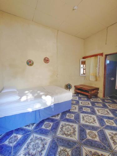 a bedroom with a bed and a tiled floor at Monkey House Hostel in Tola