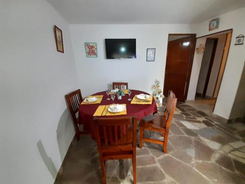 comedor con mesa y sillas en cabaña alma dorada en Huerta Grande