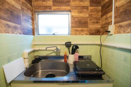 a small kitchen with a sink and a window at Yoyogi Apartment 1-401 in Tokyo