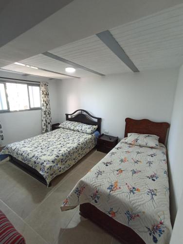 sypialnia z 2 łóżkami w pokoju w obiekcie Apartamento Central w mieście Ibagué