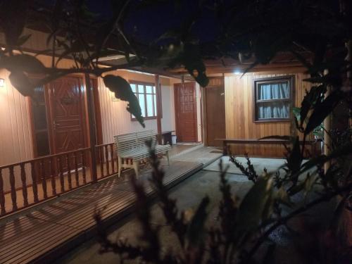 a porch of a house at night with two benches at Pousada do centro Vino & Leta in Grão Pará