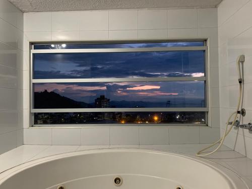 uma banheira na casa de banho com uma janela em Apartamento en Manizales em Manizales