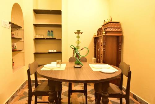 a dining room with a wooden table and chairs at Villa Dumont in Puducherry