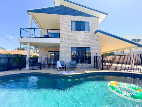 a house with a swimming pool in front of a house at Sandy Feet Retreat in Warana in Buddina