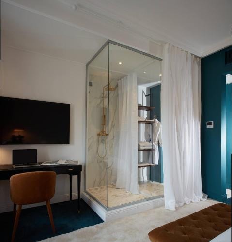 a glass shower in a room with a desk at The Townhouse in Udine