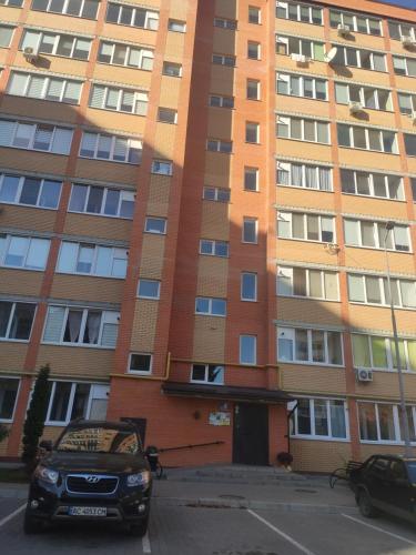 um edifício com um carro estacionado em frente em Апартаменти 1кім та 2кім ПортСіті Автостанція ЖД em Lutsk