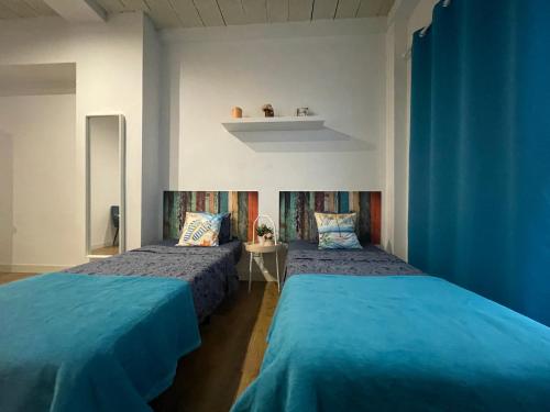 2 camas en una habitación con paredes azules en Rooms in Gothic, en Barcelona