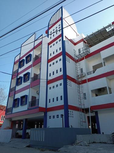 un edificio di colore rosso bianco e blu di HER MANDIRI GUEST HOUSE a Balikpapan