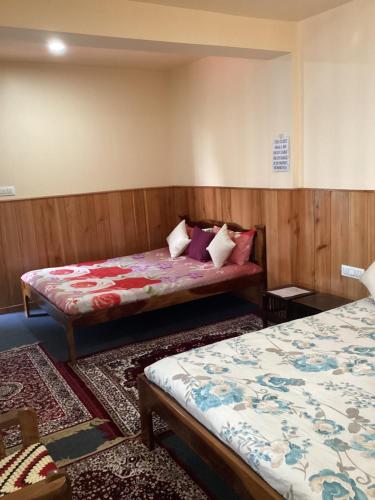 um quarto com duas camas e dois tapetes em WARUHANG HOMESTAY em Darjeeling