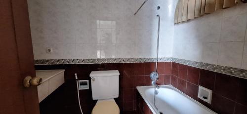 ein Badezimmer mit einem WC und einer Badewanne in der Unterkunft Sudirman Tower Condominium in Jakarta