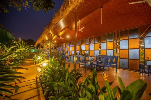 a building with chairs and tables in it at night at One At Goa in Canacona