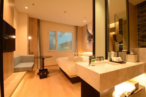 y baño con cama, lavabo y espejo. en Fairfield by Marriott Beijing Haidian, en Beijing