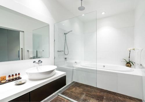 a bathroom with a sink and a tub and a shower at Park Proxi Gibraltar Bowral in Bowral
