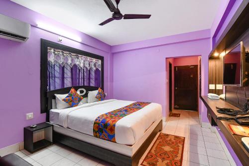 1 dormitorio con paredes moradas y 1 cama grande en FabHotel Bollywood 2.0 en Puri