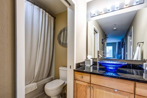 a bathroom with a toilet and a blue sink at Modern Downtown Top Floor Penthouse With Bay Views in Seattle