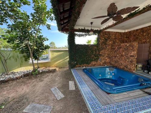 a jacuzzi tub in a yard with a building at Green Homestay in Nilai