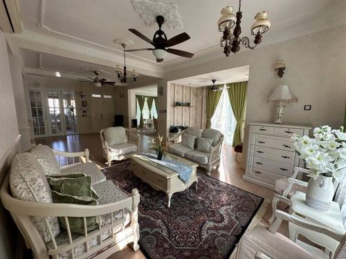 ein Wohnzimmer mit Möbeln und einem Deckenventilator in der Unterkunft Green Homestay in Nilai