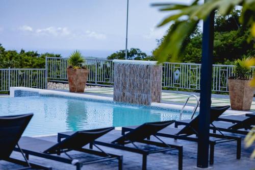 una piscina con sedie a sdraio accanto a una recinzione di Pyramid Point Manor a Ocho Rios