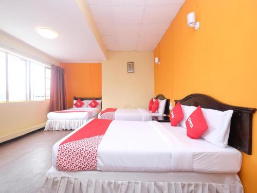 金馬崙高原的住宿－Tudor Home Inn by SECOMS，橙色墙壁客房的两张床