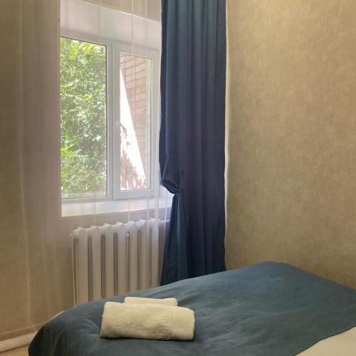 Bett mit Handtuch in einem Zimmer mit Fenster in der Unterkunft Однокомнатный номер эконом класса 