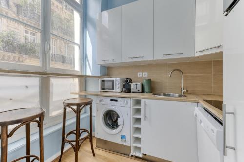 une cuisine avec une machine à laver et un évier dans l'établissement The Typical Parisian Flat - Louvre Royal - Paris 1, à Paris