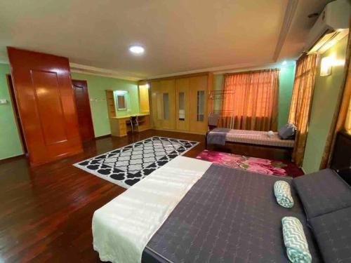 a large room with two beds and a couch at Indah Jaya Homestay in Sandakan