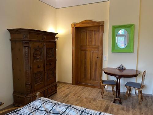 1 dormitorio con cama, mesa y armario de madera en Apartment in Aken an der Elbe, en Aken