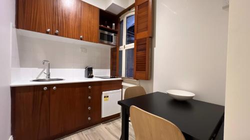 a kitchen with a black table and a sink at Gordon House Apartments in Melbourne
