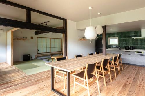 a kitchen and dining room with a wooden table and chairs at Okuaga nanamean Rakura in Aga