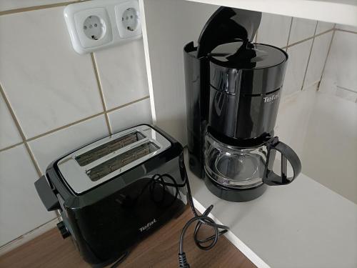einem Mixer auf einer Theke neben einer Kaffeemaschine in der Unterkunft FMI29,4Zimmer Accommodation in Raunheim