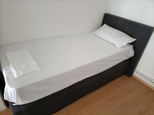 ein Bett mit einem schwarzen Rahmen und einem weißen Kissen in der Unterkunft FMI29,4Zimmer Accommodation in Raunheim