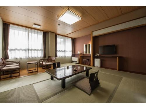 a living room with a table and chairs and a television at Kouunsou in Nasushiobara