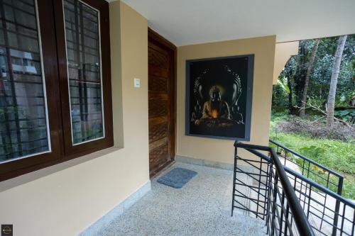 a staircase with a painting on the wall next to a door at Reunion Regal Villa in Udupi